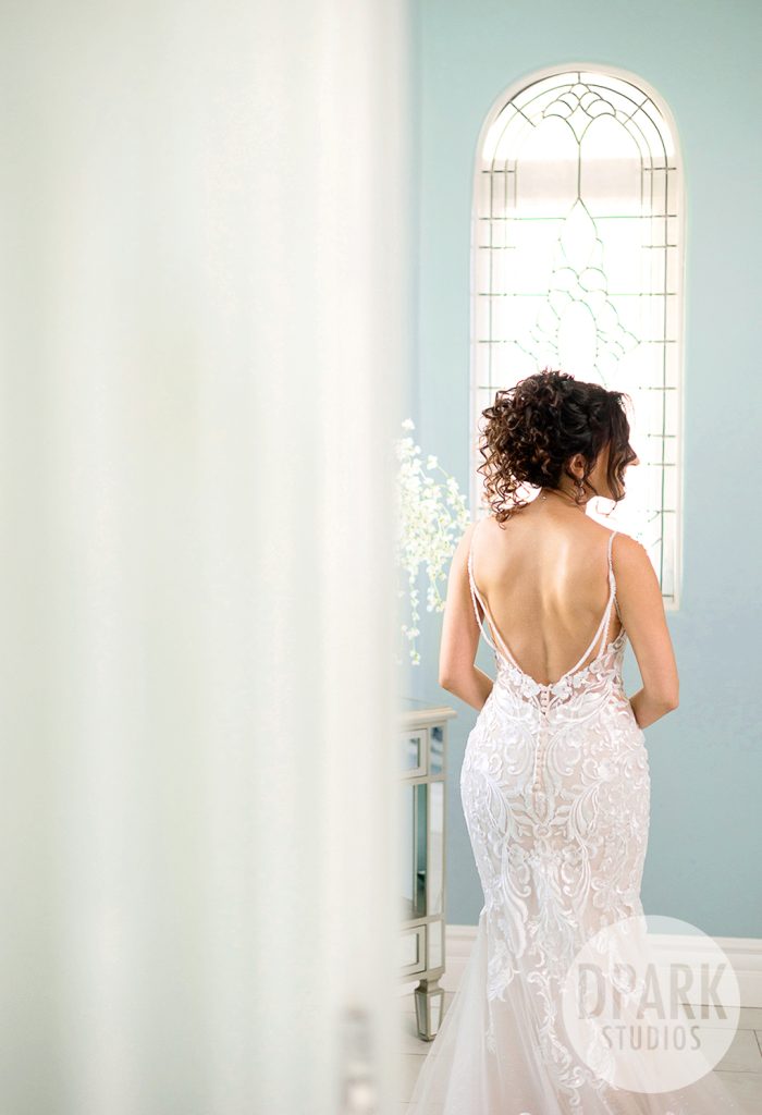 Back of the bride’s gown with detailed train in the getting ready suite