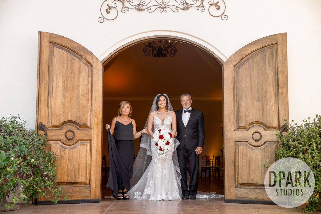 Villa De Amore garden ceremony with burgundy and gold floral arch