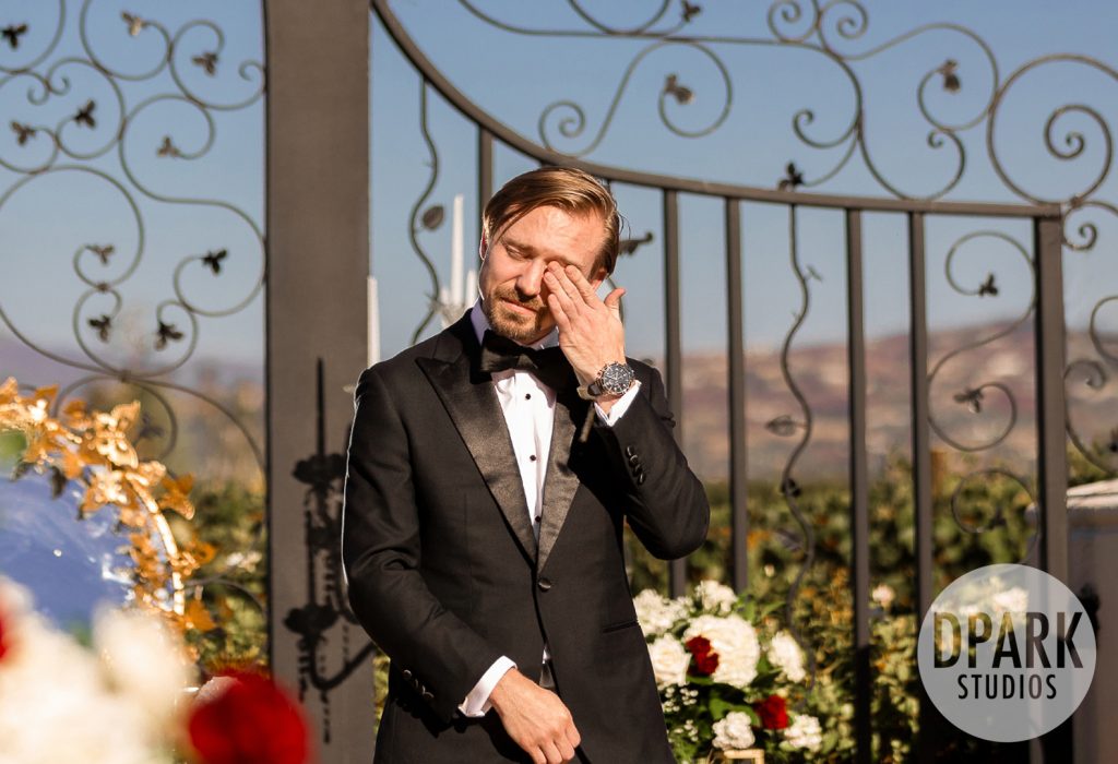 Emotional groom watching his bride at the altar