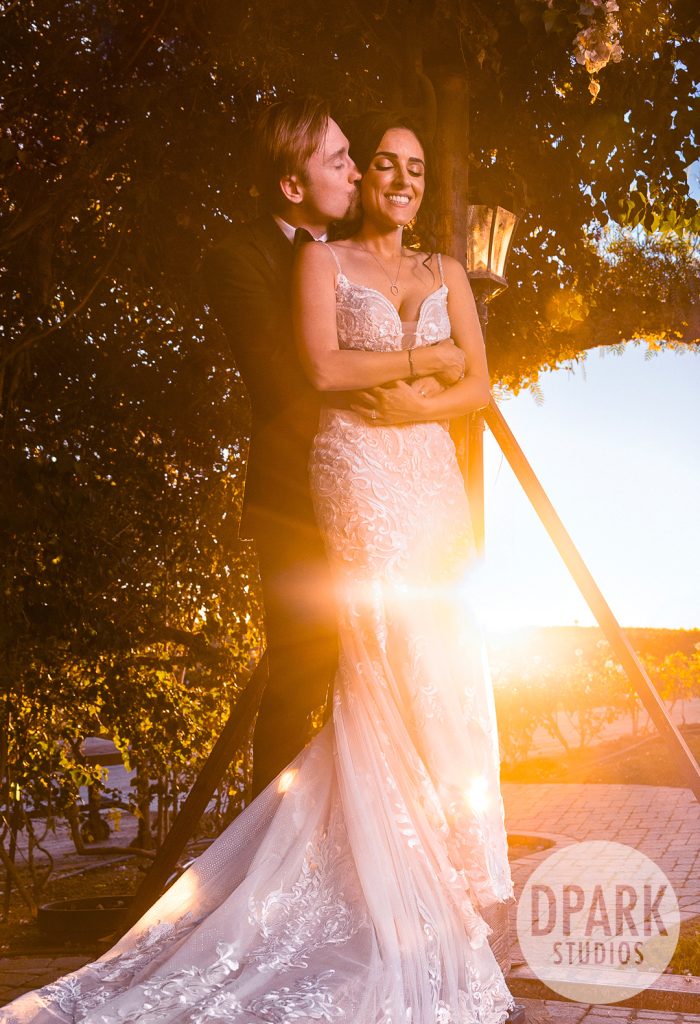 Romantic forehead kiss under Villa De Amore’s twinkle lights