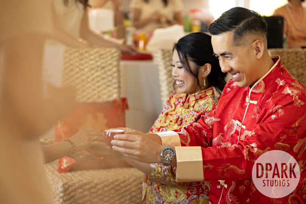Bride beaming as groom pours tea at Chinese wedding ceremony in Aliso Viejo by D. Park Studios