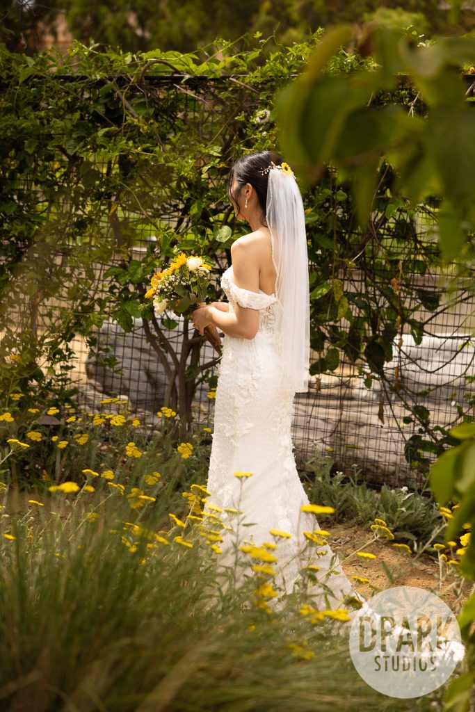Bride wearing Badgley Mischka heels with sunflower bouquet in OC farm wedding by D. Park Studios