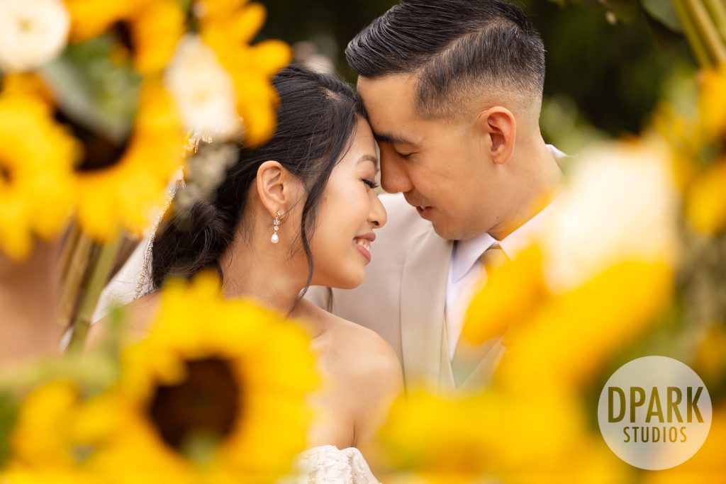 Groom checking time on Omega watch before ceremony at sunflower wedding by D. Park Studios