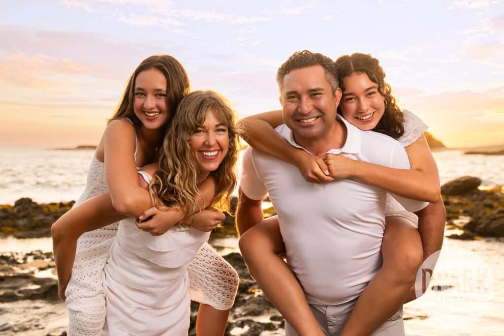 Parents laughing with their teenage daughters at Treasure Island Beach in Laguna Beach