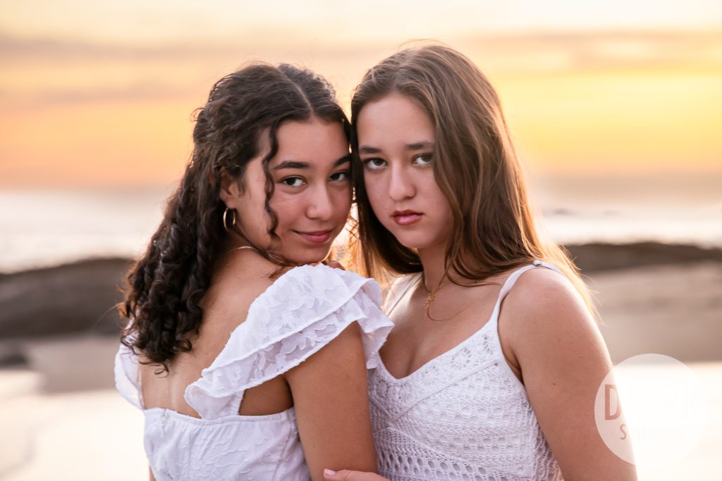 Teenage sisters laughing during Laguna Beach family photos 